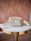Pochette blanche rendu cuir sur une table marbre et or