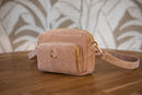 Pochette distributeur de sac d'hygiène vieux rose sur une table en bois