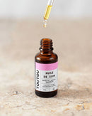 Bouteille d'huile de soin pour chien et chat marron et blanche et sa pipette